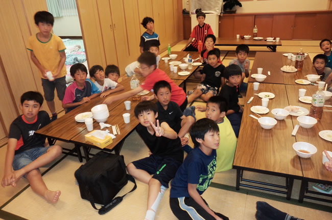 ⑥ 公民館にて、地元のブランチFCの子たちと楽しいひととき。翌日は各家庭にホームステイさせていただいた!